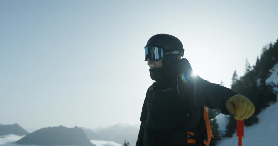 Male skier prepares to ski down a mountain slope on a winter day