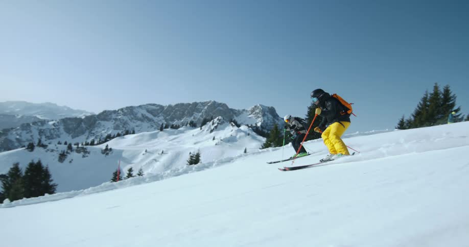 Two people are skiing down the slope