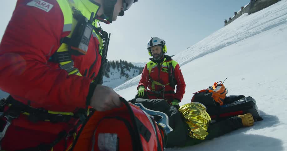Two rescue workers unpack supplies on the mountain