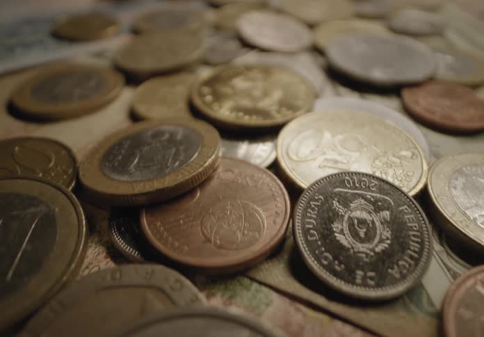 Money bills and coins against a surface indoors