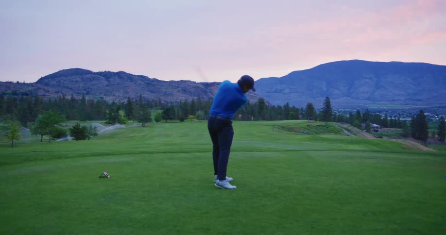 A man drives the golf ball down the course