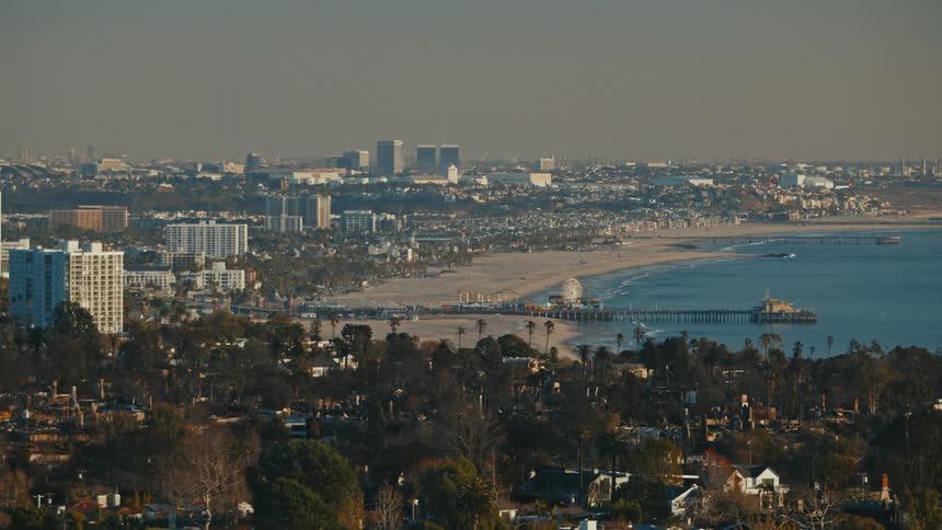 A metropolitan city facing the sea with a huge pier on the beach