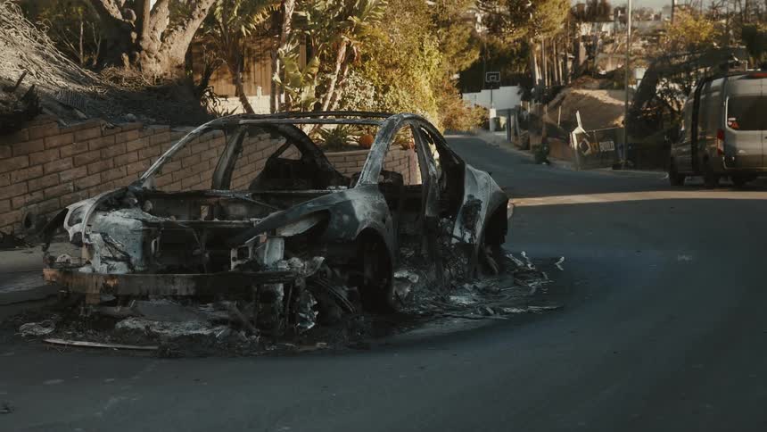 A clip of a ruined car in a community