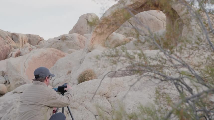 A clip of a cameraman filming a rock