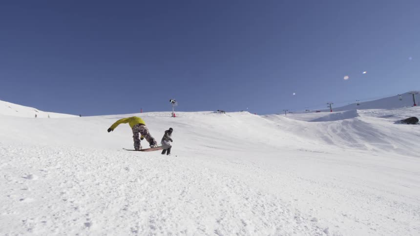 A snowboarder and a skier come down a run