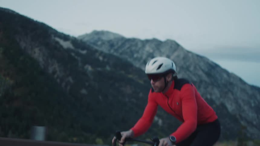 A man is pushing hard to pedal on a mountain road
