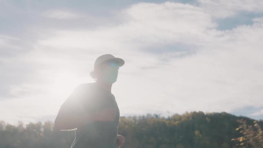 A man is out jogging on a sunny day