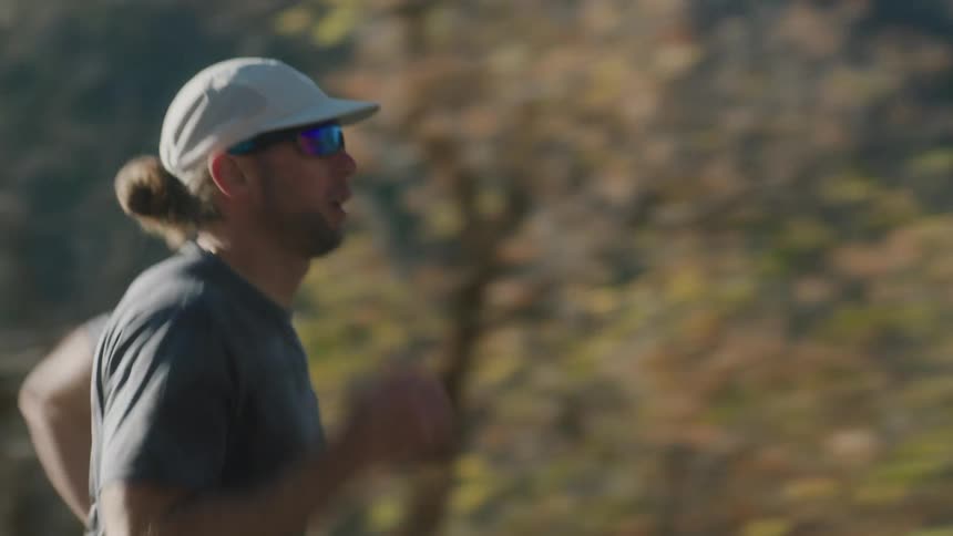 A man is jogging on a fall day