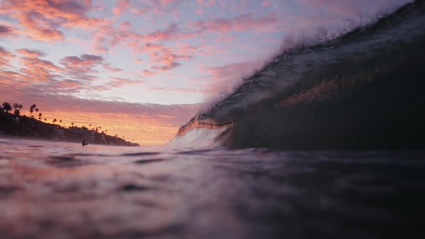 A large wave crashes by the shore