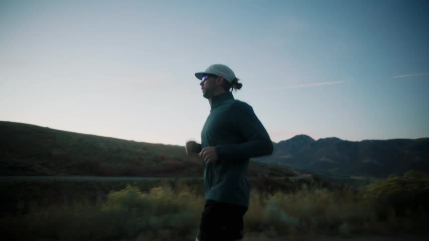 A man is jogging as the sun rises