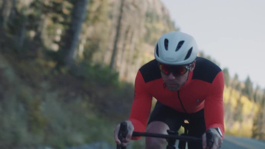 Man cyclist riding at speed on a highway in a natural environment