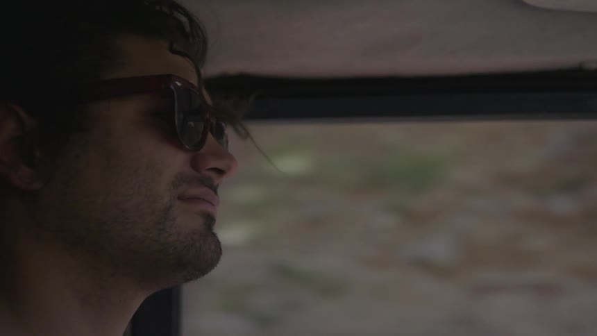 Man wearing sunglasses driving a car
