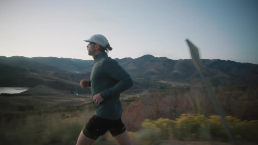 A man runs past the lake and mountains