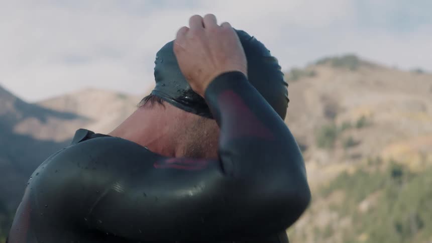 A man tightens his swimmers cap