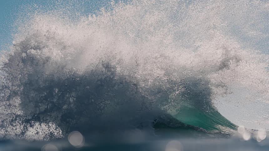 Inside the ocean a big wave with foam breaking