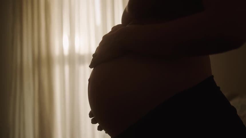 Pregnant woman with hands on her belly