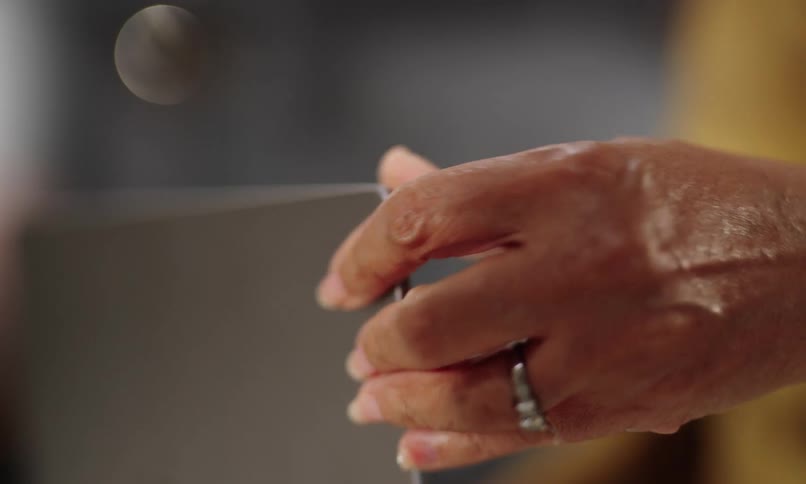 Persons hand opening a laptop