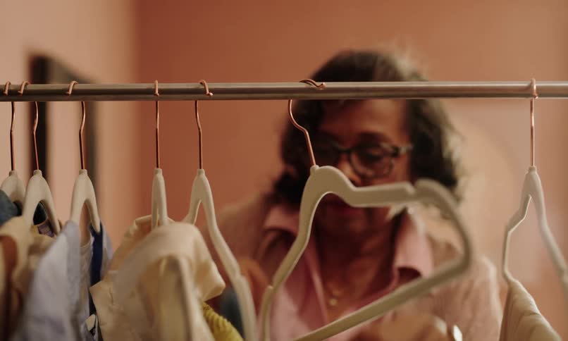 Woman takes a shirt off a hanger and examines it