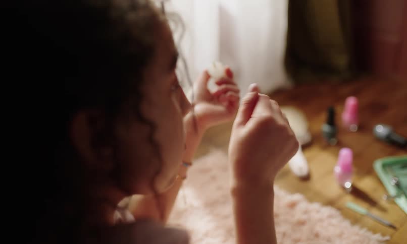 Little girl checking her nails with nail polish