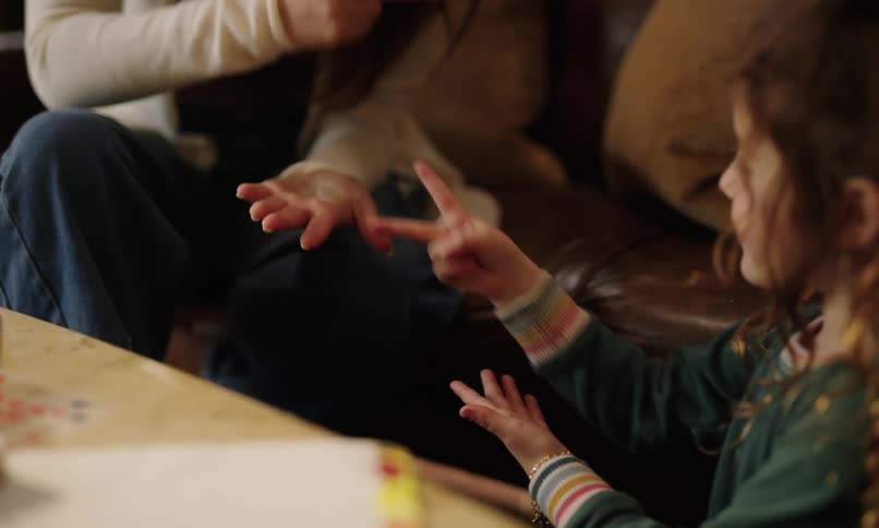 A mother and daughter are playing rock paper scissors with both showing the scissor gesture