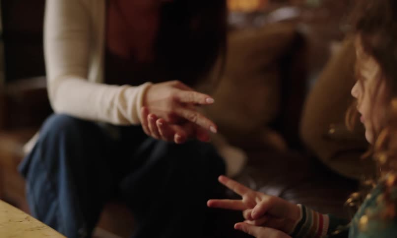 An adult and child are playing rock paper scissors