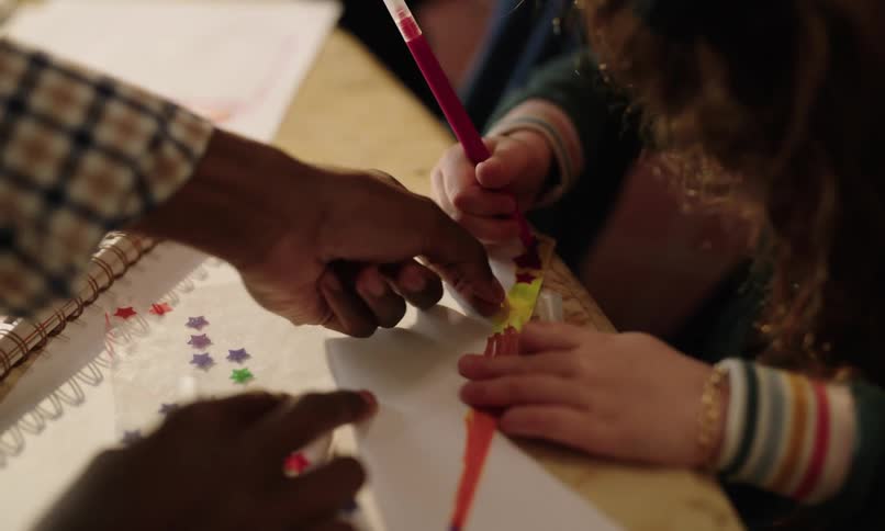 A child is drawing with a colored marker