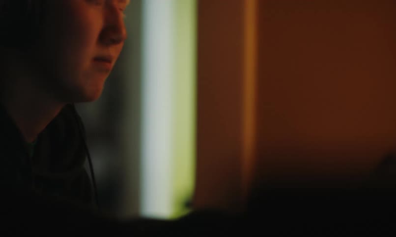 Concentrated man using headphones and interacting with a touch screen