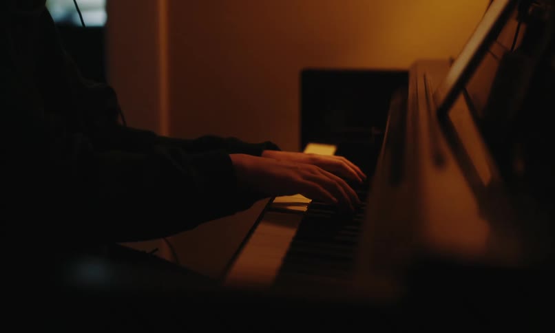 Man playing piano and interacting with a tablet in front of him