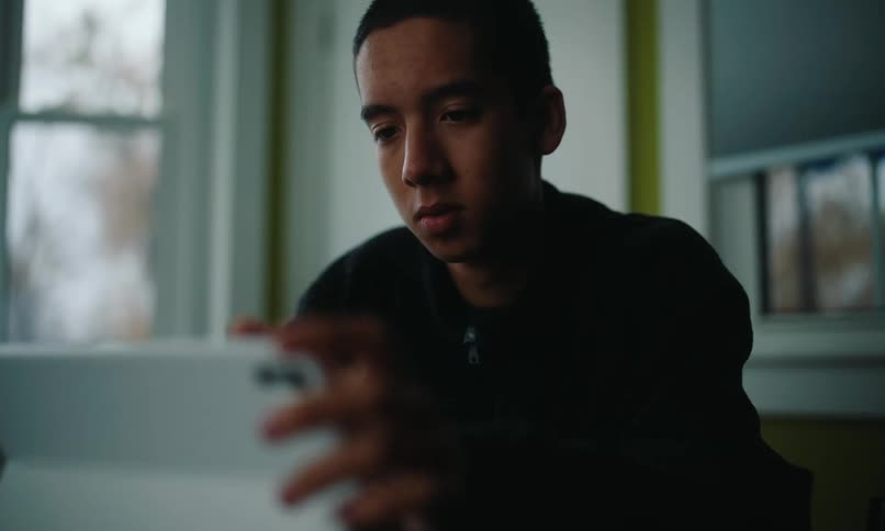 Teenager sitting interacting with a tablet