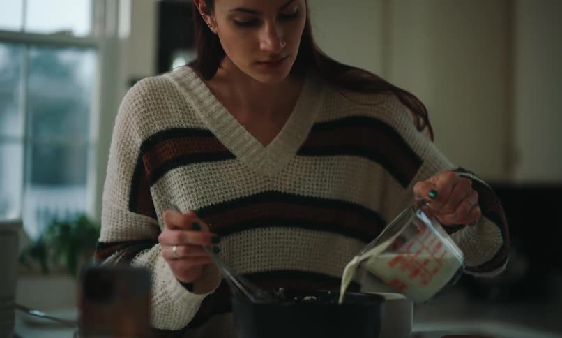 A woman is cooking in the kitchen