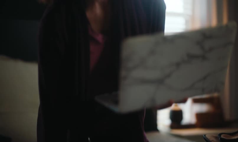 A woman takes a laptop out of a yellow bag and opens it