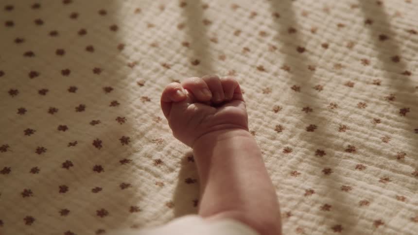Babys hand moving while lying down