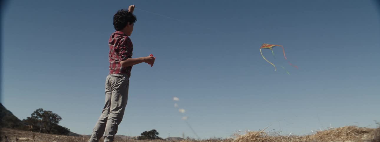 A child is running while flying a kite