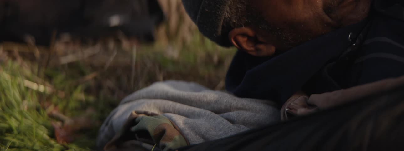 Man waking up while lying on grass outdoors