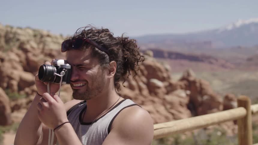 Man taking photographs of mountains on a sunny day