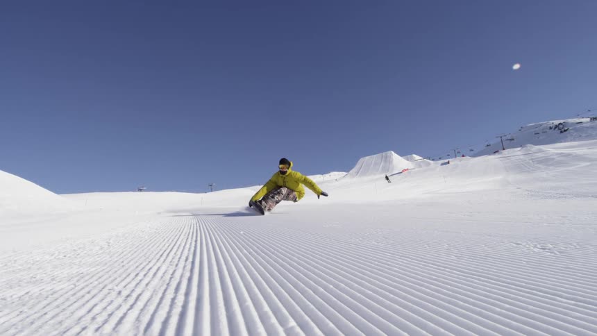 A snowboarder rides down a mountain