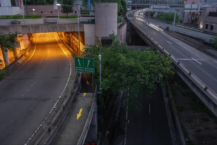 Highway and an overpass with heavy vehicle traffic and the day getting dark
