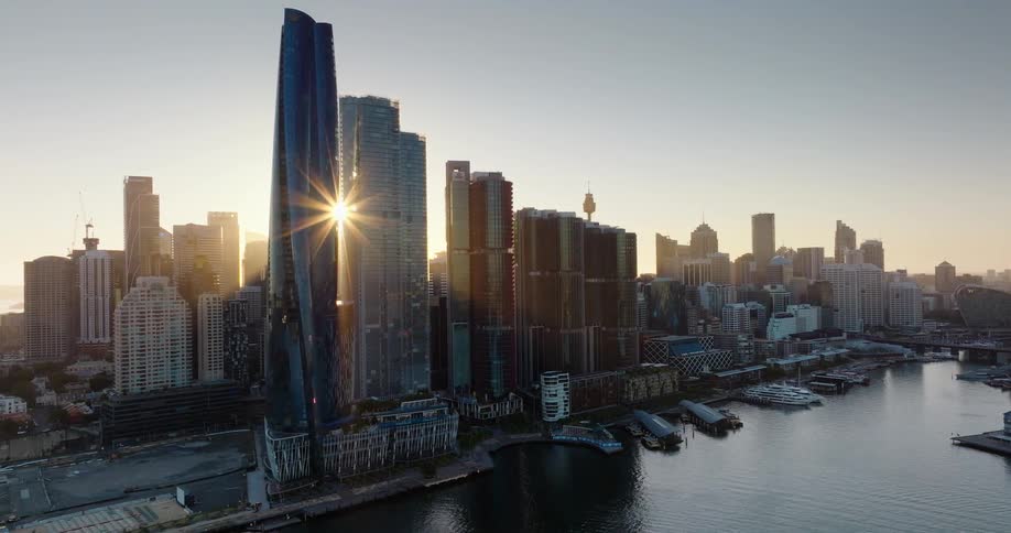 Modern skyscrapers of a metropolis surrounded by the sea with the sunrise on the horizon