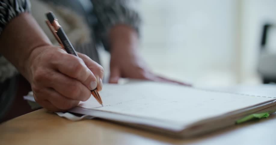 Hand with a pen writing in a notebook
