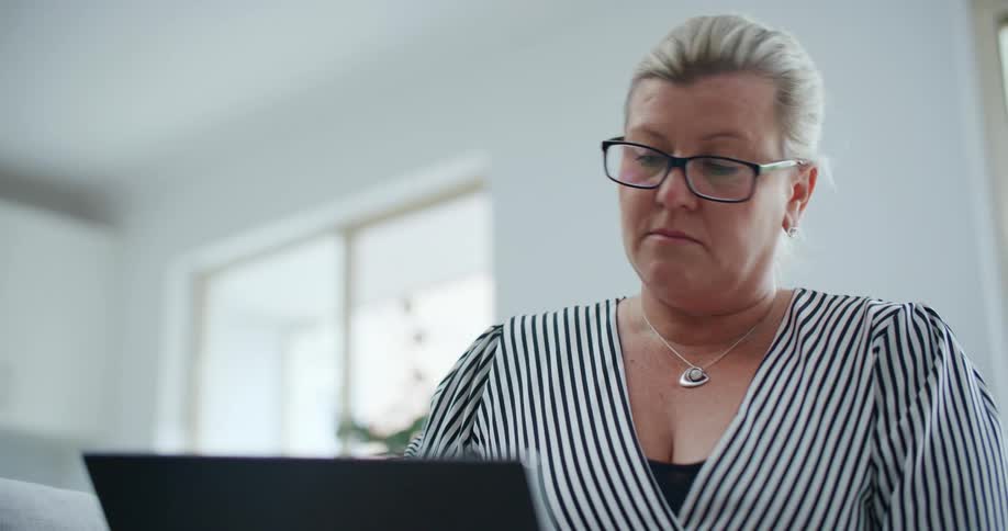 Woman with glasses interacting with a laptop