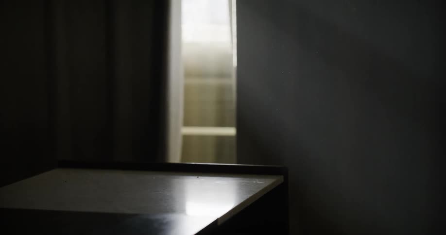 Crack in a window with sunlight entering a room in a house