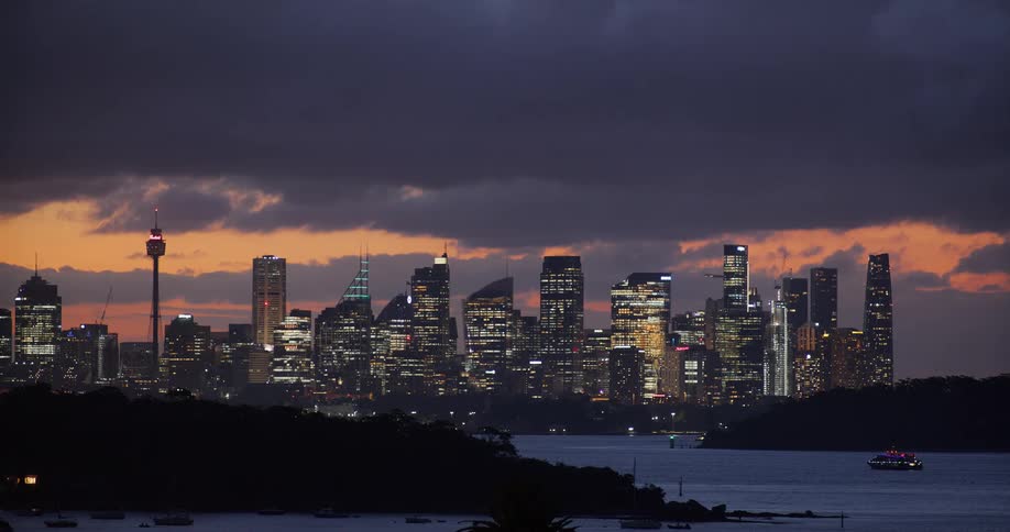 Panorama of a metropolis illuminated at dusk and the seaside