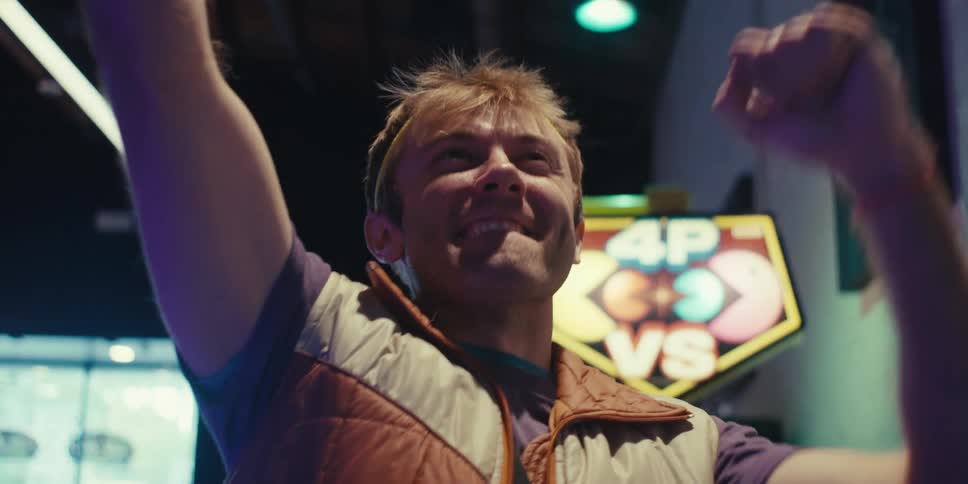 Man celebrating a victory while playing arcade machines