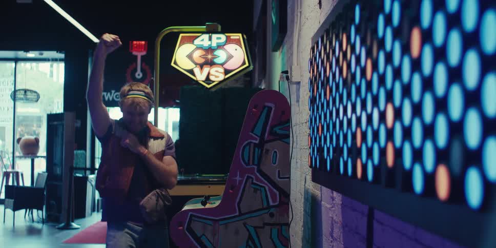 A man cheers while playing the game in the arcade