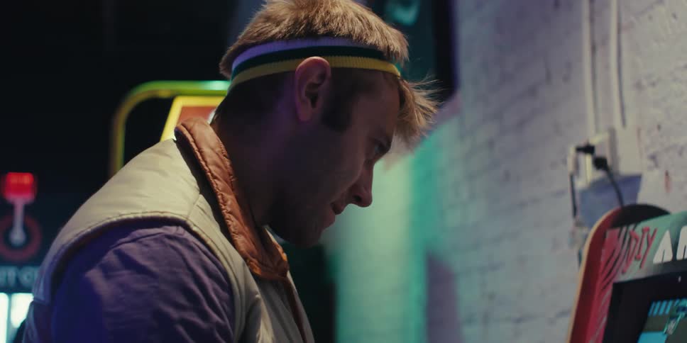 A man is playing an arcade cabinet
