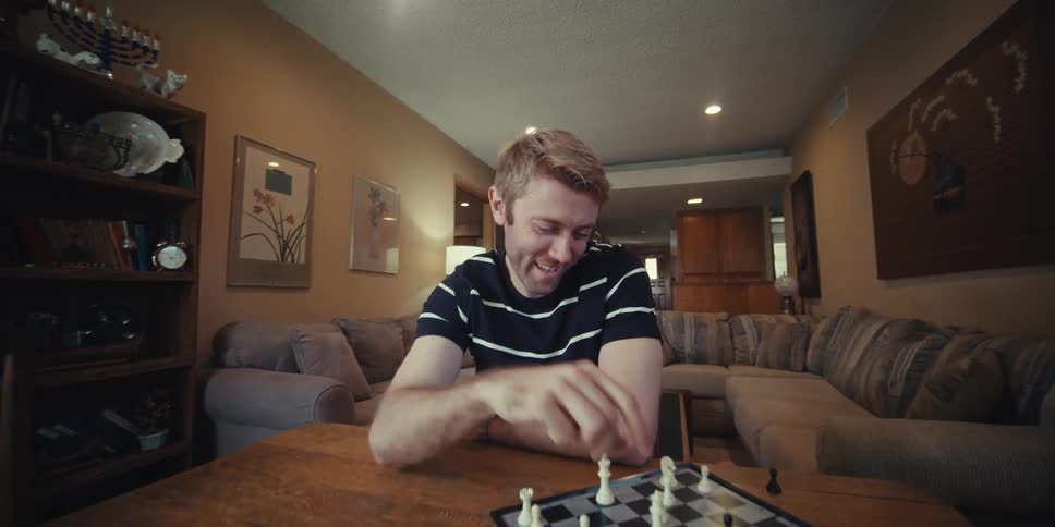 Two men smile while playing chess