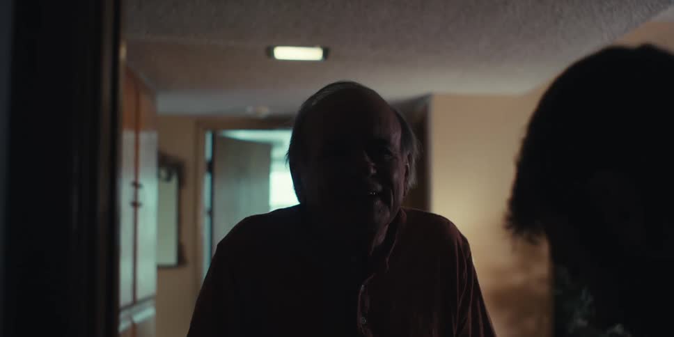 Man helping an elderly man walk down the hallway