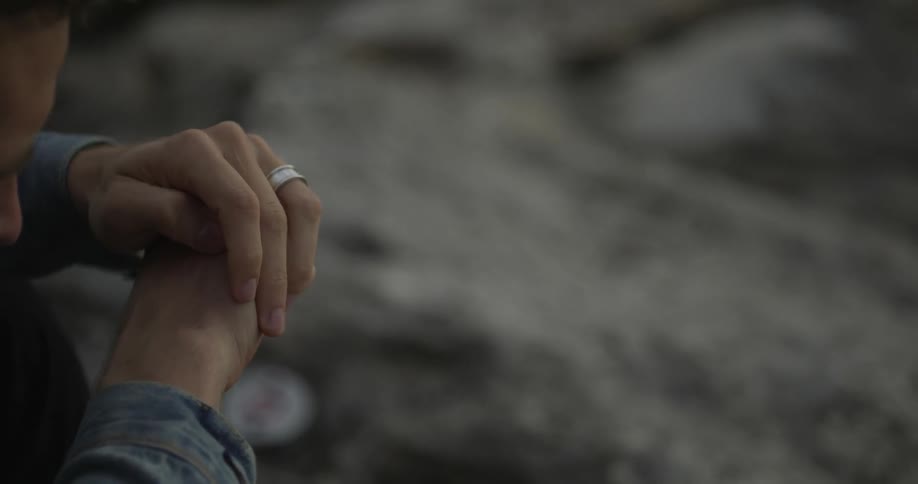 A man contemplates and rubs his hands together