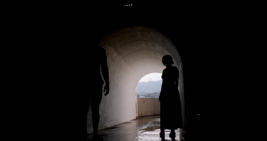 Silhouette of a man and a woman kissing in a tunnel corridor