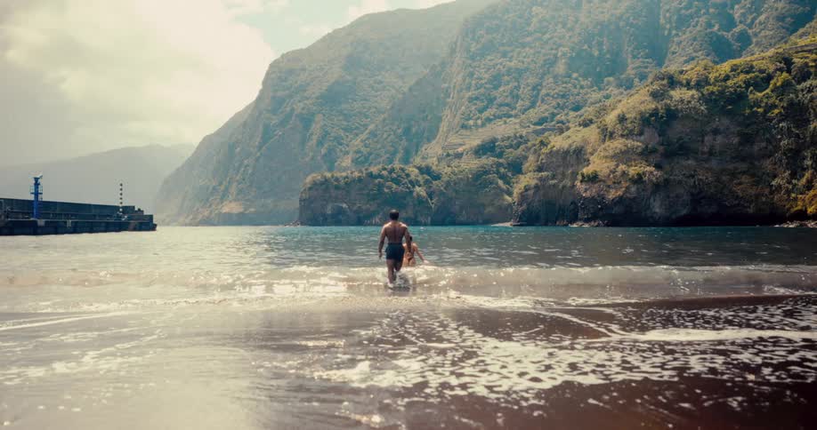 Man and a woman entering the sea from the beach
